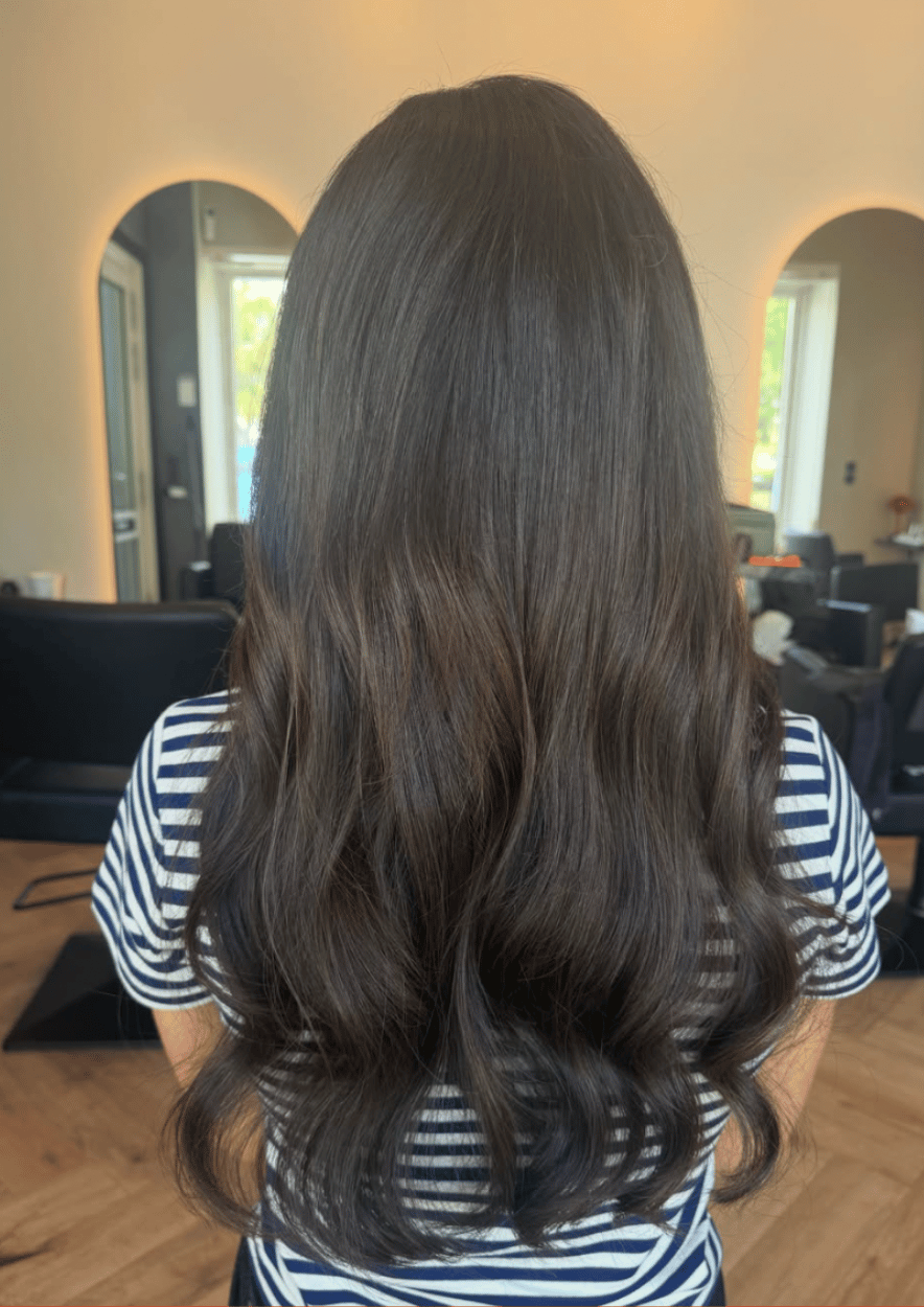 Langt brunt hår med bløde bølger, lavet hos Staack Hair i Lyngby